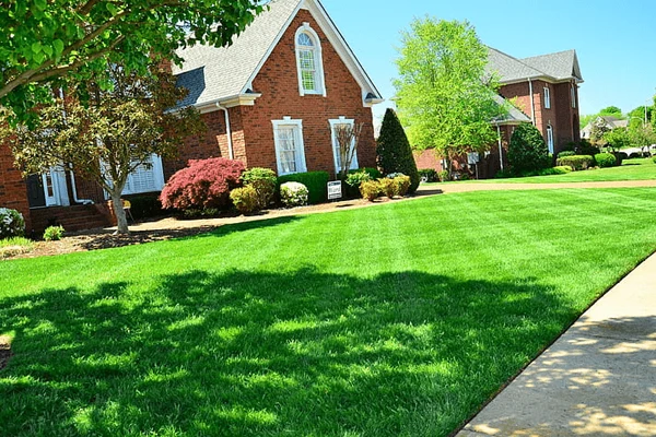 A large red home with a freshly cut lawn with the cross hatching design.