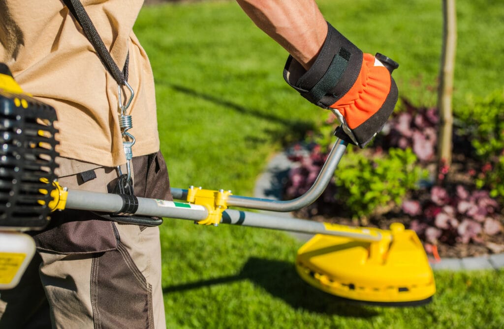 Cape Coral lawn professional using a leaf blower to clean up yard.